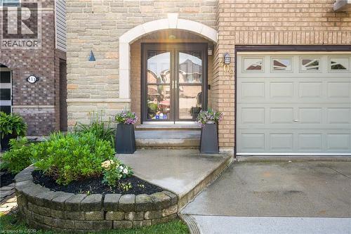 Brick and stone veneer facade with an arched entryway featuring glass double doors - 409 Jacqueline Boulevard, Hamilton, ON 