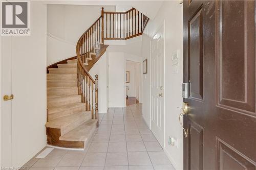 Entryway featuring a curved staircase with wood banister and carpeted treads - 409 Jacqueline Boulevard, Hamilton, ON 