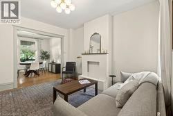 Living area featuring a minimalist fireplace surround, neutral wall tones, and a multi-bulb ceiling fixture - 