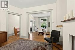 Open doorways with contrasting trim, wood-finish flooring, and a built-in fireplace mantel - 