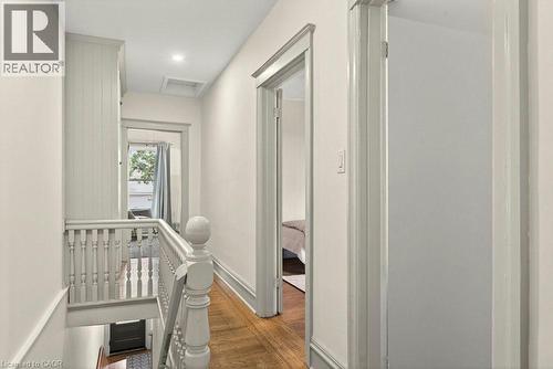 Upper-level hallway featuring wood-finish flooring, light-toned walls, and recessed ceiling lighting - 148 Dundurn Street N, Hamilton, ON 