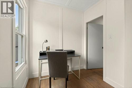 Warm wood-finish flooring complements the crisp white walls and panel molding - 148 Dundurn Street N, Hamilton, ON 
