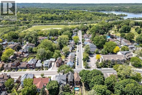 Aerial perspective showcasing a residential neighborhood with tree-lined streets, a distant body of water, and surrounding green spaces - 148 Dundurn Street N, Hamilton, ON 