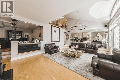 Spacious living area featuring light wood-finish flooring, a vaulted ceiling, and an open concept layout - 712 Highvalley Road, Ancaster, ON 