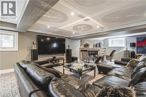 Finished lower level featuring a stone-clad fireplace and a coffered ceiling with recessed lighting - 712 Highvalley Road, Ancaster, ON 