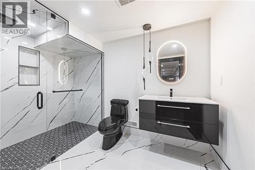 Contemporary bathroom featuring a floating vanity with a vessel sink, an illuminated oval mirror, and a frameless glass shower enclosure - 712 Highvalley Road, Ancaster, ON 