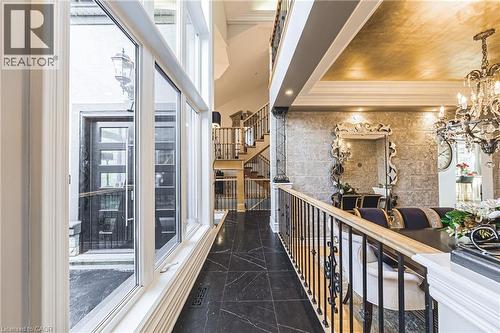 Grand entry foyer featuring a two-story window array, black tile flooring, and a decorative front door - 712 Highvalley Road, Ancaster, ON 