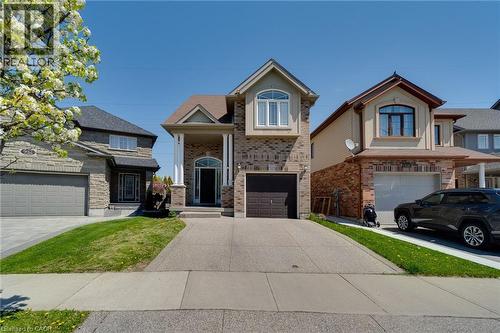 Brick facade residence featuring a prominent arched entry, a two-car garage, and a concrete driveway - 928 Dunblane Court, Kitchener, ON - Outdoor With Facade