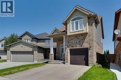 Brick and siding exterior featuring an attached single-car garage and a paved driveway - 