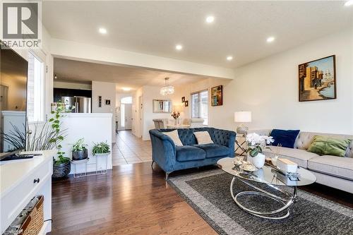 Hardwood-finish flooring throughout the living space, featuring recessed ceiling lighting, a cased opening, and a kitchen visible with stainless steel appliances - 928 Dunblane Court, Kitchener, ON - Indoor Photo Showing Living Room