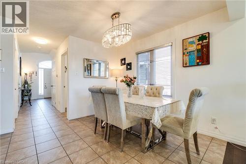 Open-concept dining area featuring a contemporary chandelier and tiled flooring - 928 Dunblane Court, Kitchener, ON - Indoor Photo Showing Dining Room