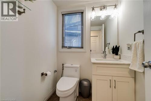 Bathroom featuring a single vanity with a white countertop and base cabinetry, brushed nickel hardware, an integrated sink, and an overhead vanity light fixture - 928 Dunblane Court, Kitchener, ON - Indoor Photo Showing Bathroom