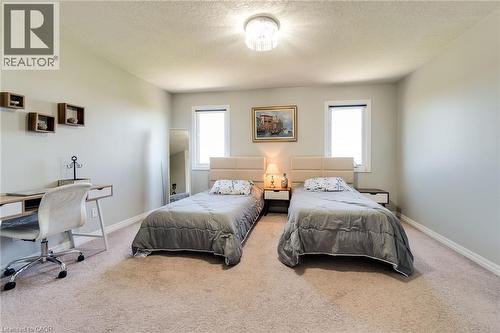 Carpeted interior space featuring light gray walls, two windows, and a ceiling-mounted light fixture - 928 Dunblane Court, Kitchener, ON - Indoor Photo Showing Bedroom
