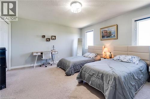 Carpeted room featuring light gray walls, two windows, and a flush-mount ceiling light fixture - 928 Dunblane Court, Kitchener, ON - Indoor Photo Showing Bedroom