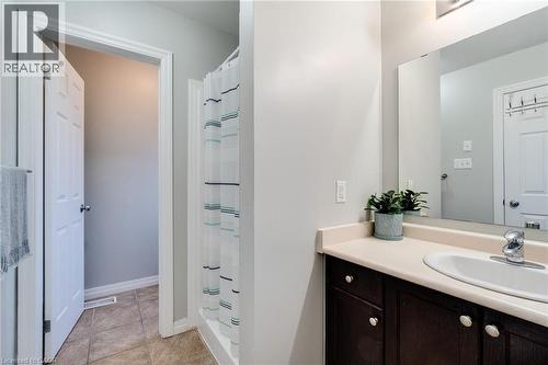 Bathroom featuring a dark wood-finish vanity with a built-in sink, a neutral countertop, and a vanity mirror - 928 Dunblane Court, Kitchener, ON - Indoor Photo Showing Bathroom