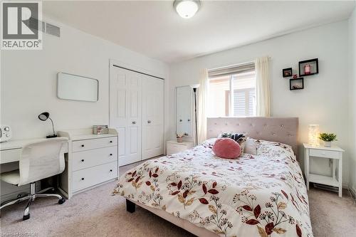 Bright room featuring light-toned carpeting, a window with horizontal blinds, and a ceiling-mounted light fixture - 928 Dunblane Court, Kitchener, ON - Indoor Photo Showing Bedroom