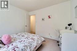 Neutral interior room featuring white walls and light-colored carpeting - 