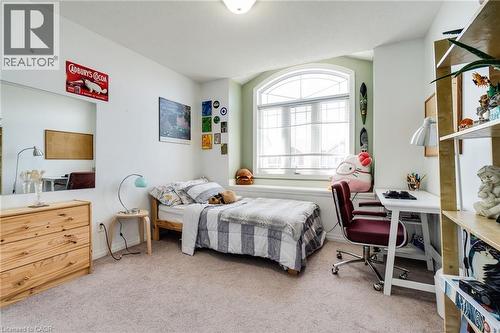 Bright room featuring a large arched window with a window seat, light-toned carpet, and neutral wall tones - 928 Dunblane Court, Kitchener, ON - Indoor Photo Showing Bedroom