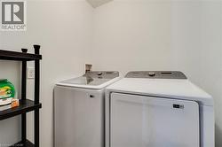 Dedicated laundry space featuring white walls and a functional shelving unit - 
