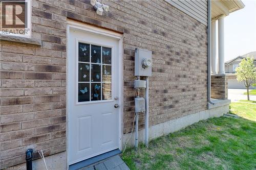 White exterior door with upper window panes, set within a brick facade - 928 Dunblane Court, Kitchener, ON - Outdoor With Exterior