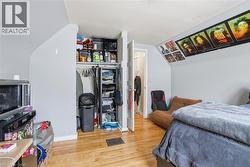 Hardwood-style flooring throughout this room, featuring light gray painted walls and a sloped ceiling - 