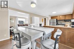 Kitchen and dining area featuring wood-finish flooring, recessed lighting, and an open pass-through to an adjacent living space - 