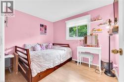 Room featuring light wood-finish flooring, a bright window with a white blind, and built-in white floating shelves - 