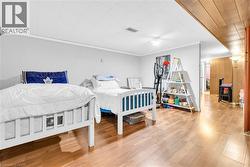 Spacious area featuring light grey walls, white trim, wood-finish flooring, and a white acoustical tile ceiling - 