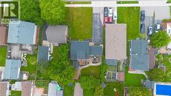 Aerial perspective showcasing the property's roofline, surrounding green spaces, and paved driveway - 