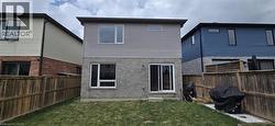 Rear exterior featuring a manicured lawn, full privacy fencing, and a combination of brick and siding finishes - 
