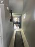 Hallway featuring light-toned rectangular floor tiles, neutral wall paint, and white baseboards - 766 Freeport Street, London, ON 