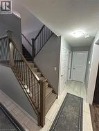 Staircase with wood newel posts, black metal balusters, and carpeted treads - 