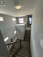 Multi-level staircase featuring carpeted treads and risers, wood-finish handrails, and black metal balusters - 