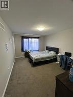 Carpeted room with a window featuring privacy sheers and dark drapes - 