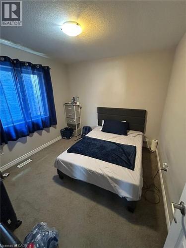 Carpeted room featuring a window with a white frame and light-colored walls - 766 Freeport Street, London, ON 