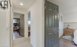 Hallway featuring light carpeting, recessed lighting, white walls, and a dark paneled door - 