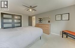 Bedroom featuring light-toned carpeting and a ceiling fan with integrated lighting - 