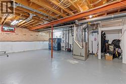 Unfinished basement with painted concrete flooring and exposed ceiling joists - 