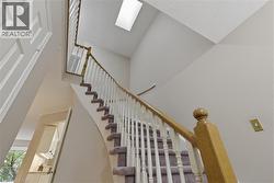 Curved staircase featuring wood-finish handrails and white balusters - 