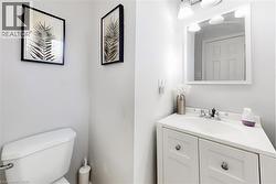 White vanity with a built-in sink, chrome fixtures, and a framed mirror with overhead lighting - 