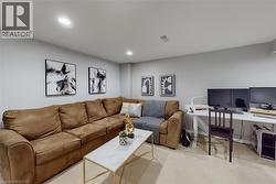 Recessed lighting illuminates this versatile space featuring neutral wall tones and plush carpeting - 