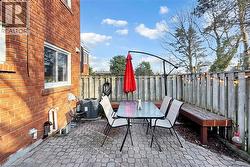 Brick exterior featuring multiple windows and a patio with paver stones - 