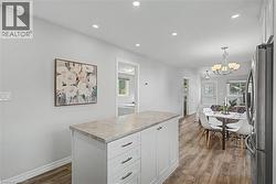 Kitchen island with storage, recessed lighting, and vinyl flooring - 
