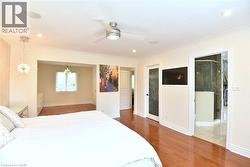 Hardwood flooring extends throughout this space, featuring crown molding, recessed lighting, and a ceiling fan - 
