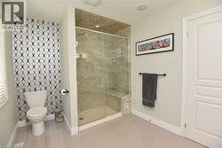 Glass-enclosed shower with stone-tiled walls and a built-in bench - 