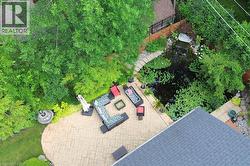 Stamped concrete patio with a tiered fountain, surrounded by mature trees and lush landscaping - 
