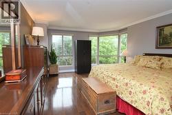 Hardwood-finish flooring extending throughout, bay windows, crown molding, and neutral wall tones - 