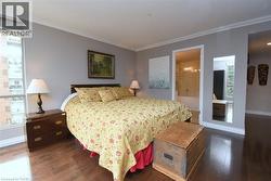 Spacious sleeping area featuring wood-finish flooring and grey wall tones - 