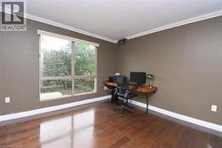 Room with hardwood flooring, large picture window, crown molding, and baseboard trim - 