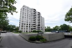 White multi-story building featuring multiple balconies and bay windows - 